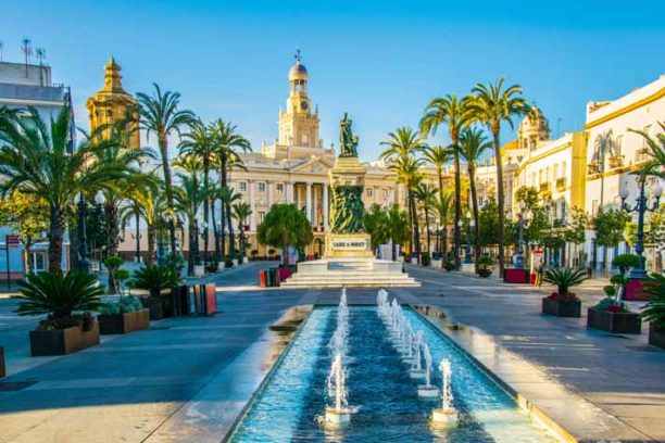 View of a fountain situated on the square of saint john of god in cadiz with town hall on background